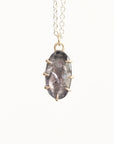 Necklace with a pendant featuring a gray stone and gold accents on a white background