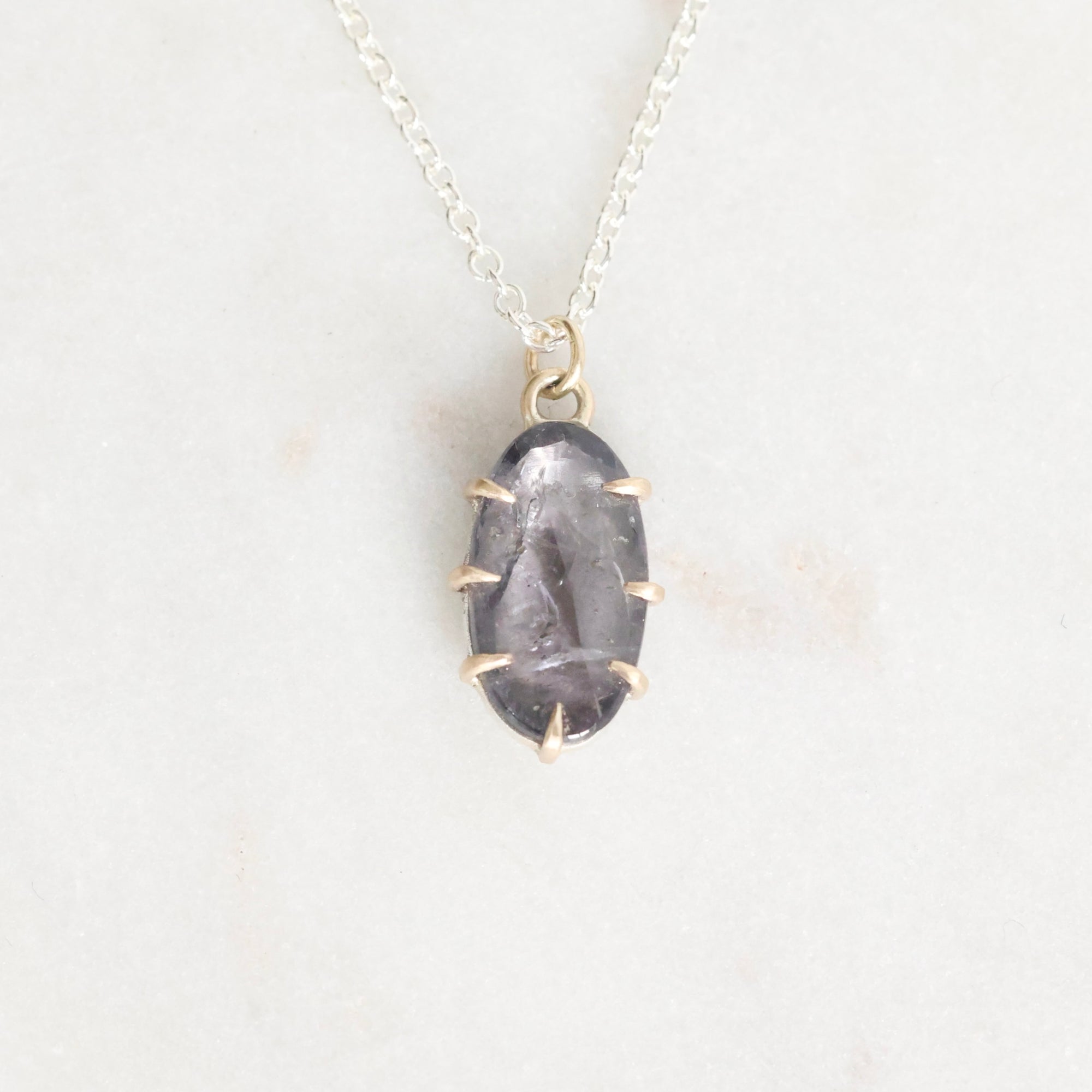 Necklace with a dark stone pendant on a light gray background