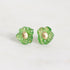 A pair of green flower-shaped stud earrings with a gold-tone center, shown on a plain light gray background.