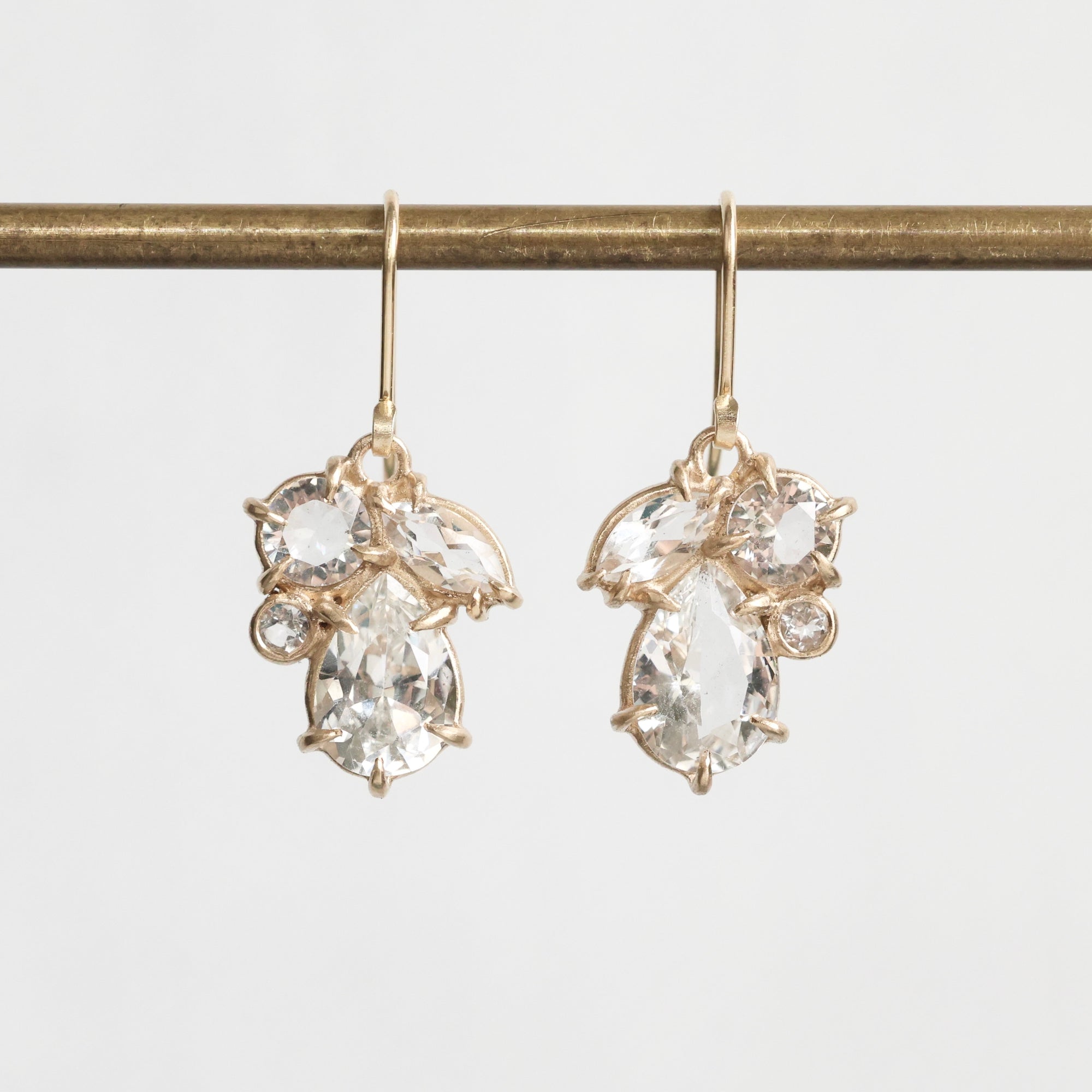 Gold earrings with clear gemstones on a white background