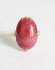 Ring with a large pink stone and gold accents on a white background