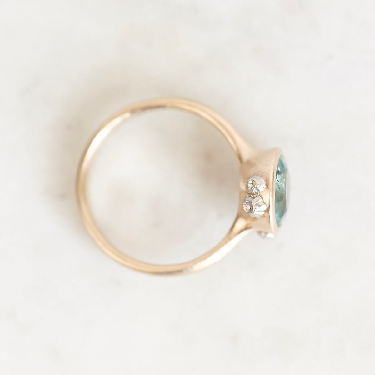 Ring from above gold bezel set with platinum barnacle details. Stone is blue/green.