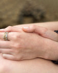 Close-up of hands with gold rings on a blurred natural background
