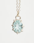 Silver necklace with a light blue gemstone pendant on a white background