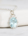 Necklace with a light blue gemstone pendant on a white background