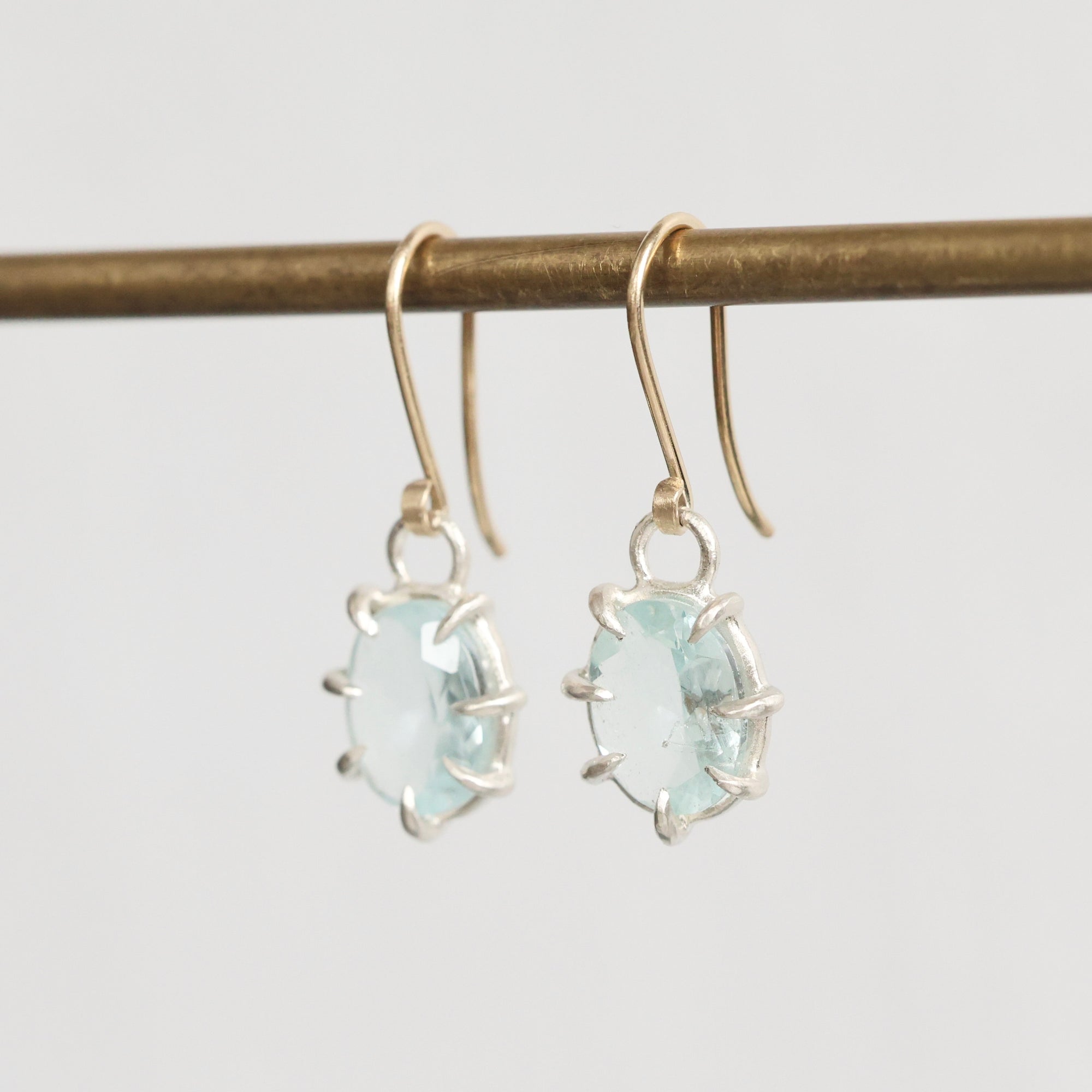 Pair of earrings with light blue gemstones on a white background