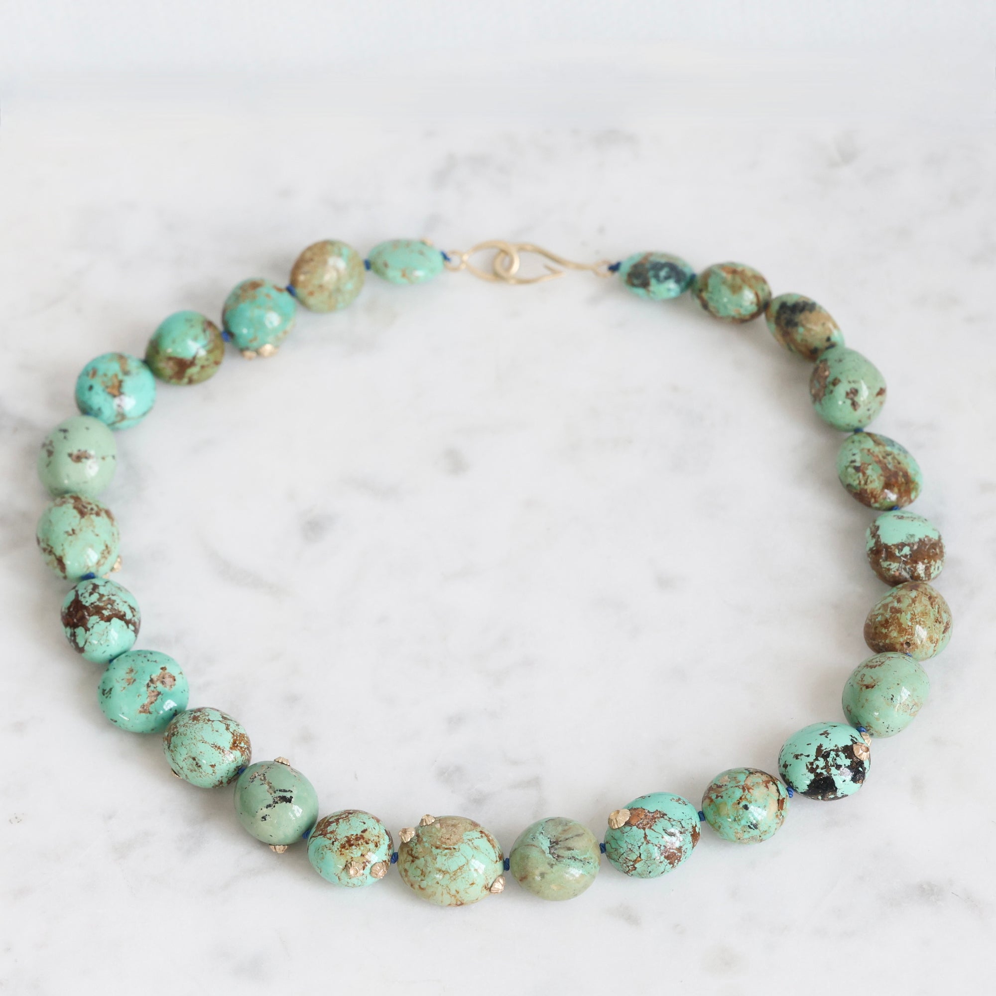 Turquoise beaded necklace on a marble surface
