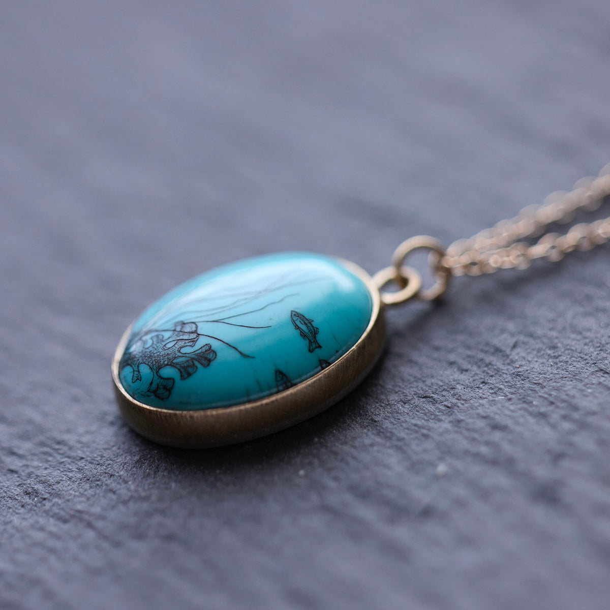 Scrimshaw necklace at an angle featuring seascape 