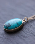 Scrimshaw necklace at an angle featuring seascape 