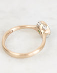 A vintage-style rose gold ring with a small cluster of clear gemstones on the setting, photographed on a light marble surface. The inside of the band shows a '10K' stamp.