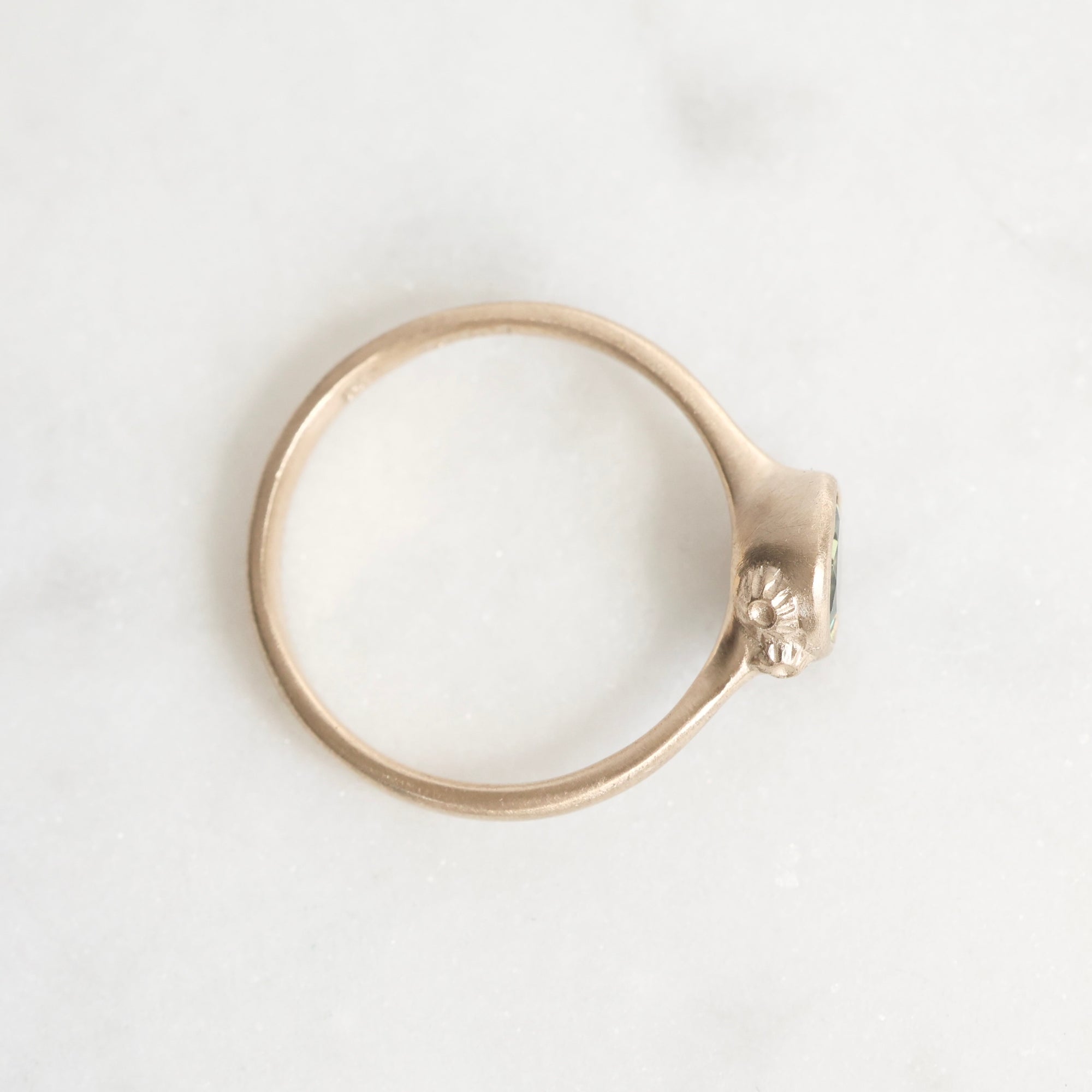 Gold ring with a unique design on a white background