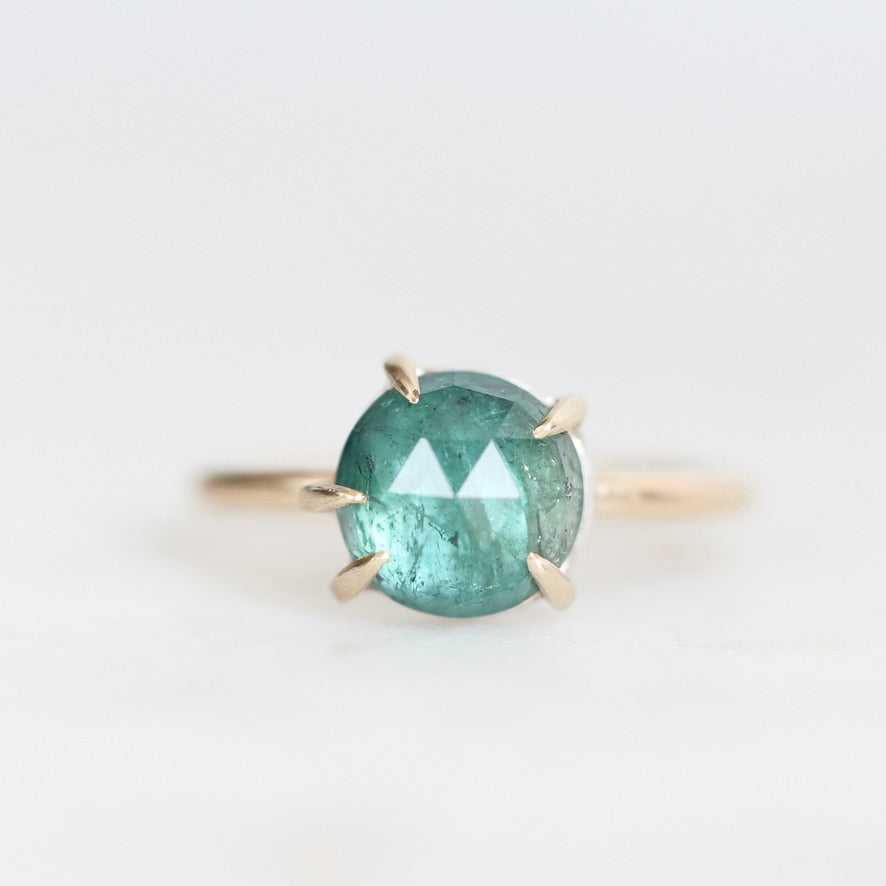 Green stone ring with inclusions and prongs