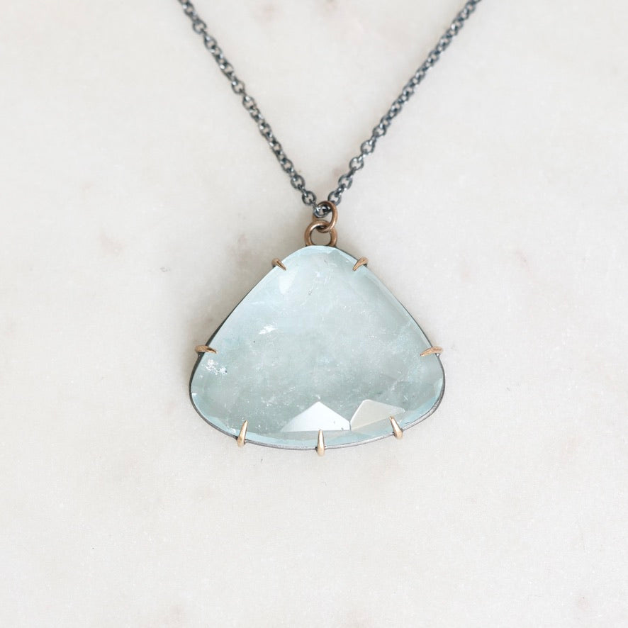 Blue topaz necklace with oxidized chain and setting. Gold prongs