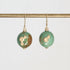 Pair of green earrings with gold accents on a white background