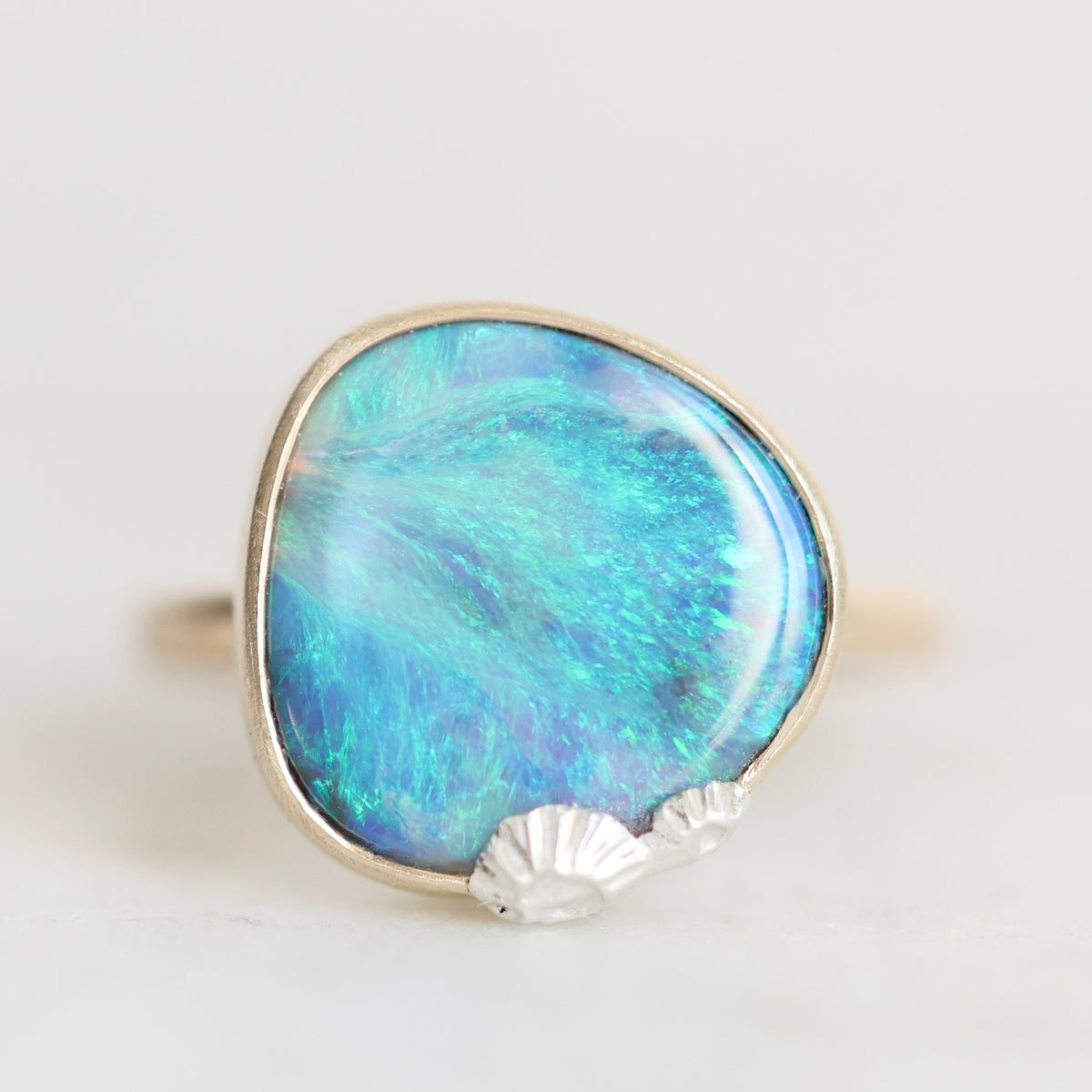 Large opal set in a bezel with silver barnacles clinging to the bezel. 