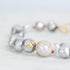 Close-up of a pearl bracelet with gold accents on a light background