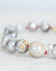 Close-up of a pearl bracelet with gold accents on a light background