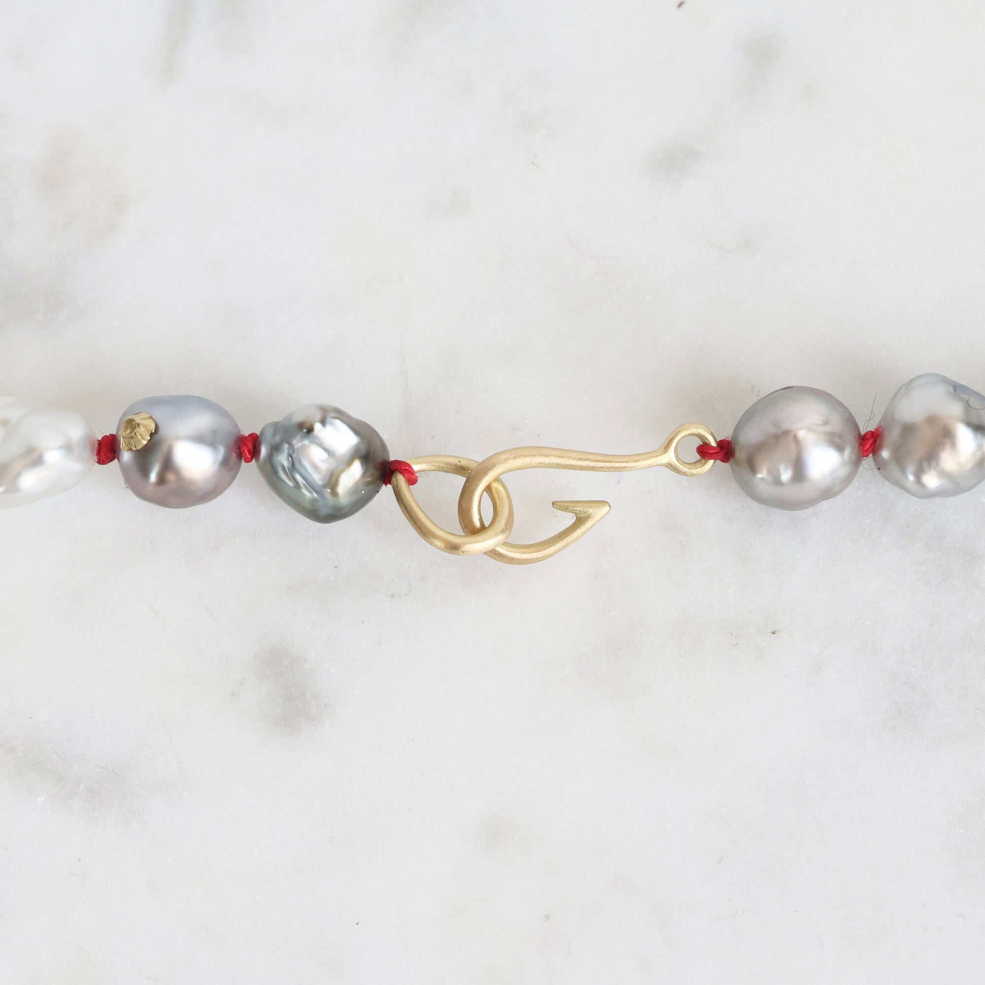 Pearl necklace with a gold clasp on a white background