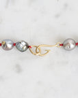 Pearl necklace with a gold clasp on a white background