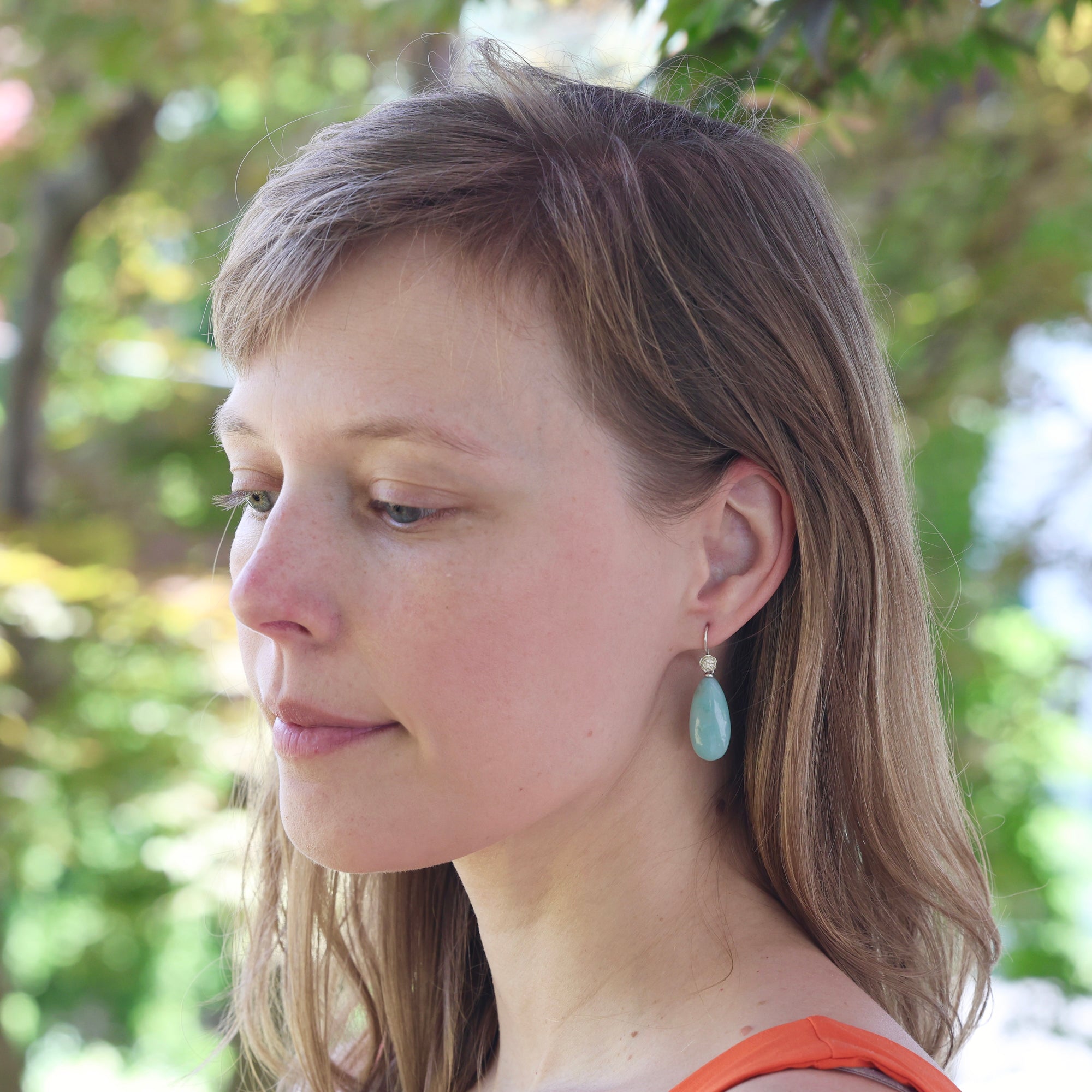 Woman wearing earrings with a blurred natural background