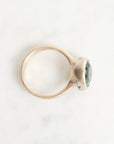 Gold ring with a green gemstone on a white background