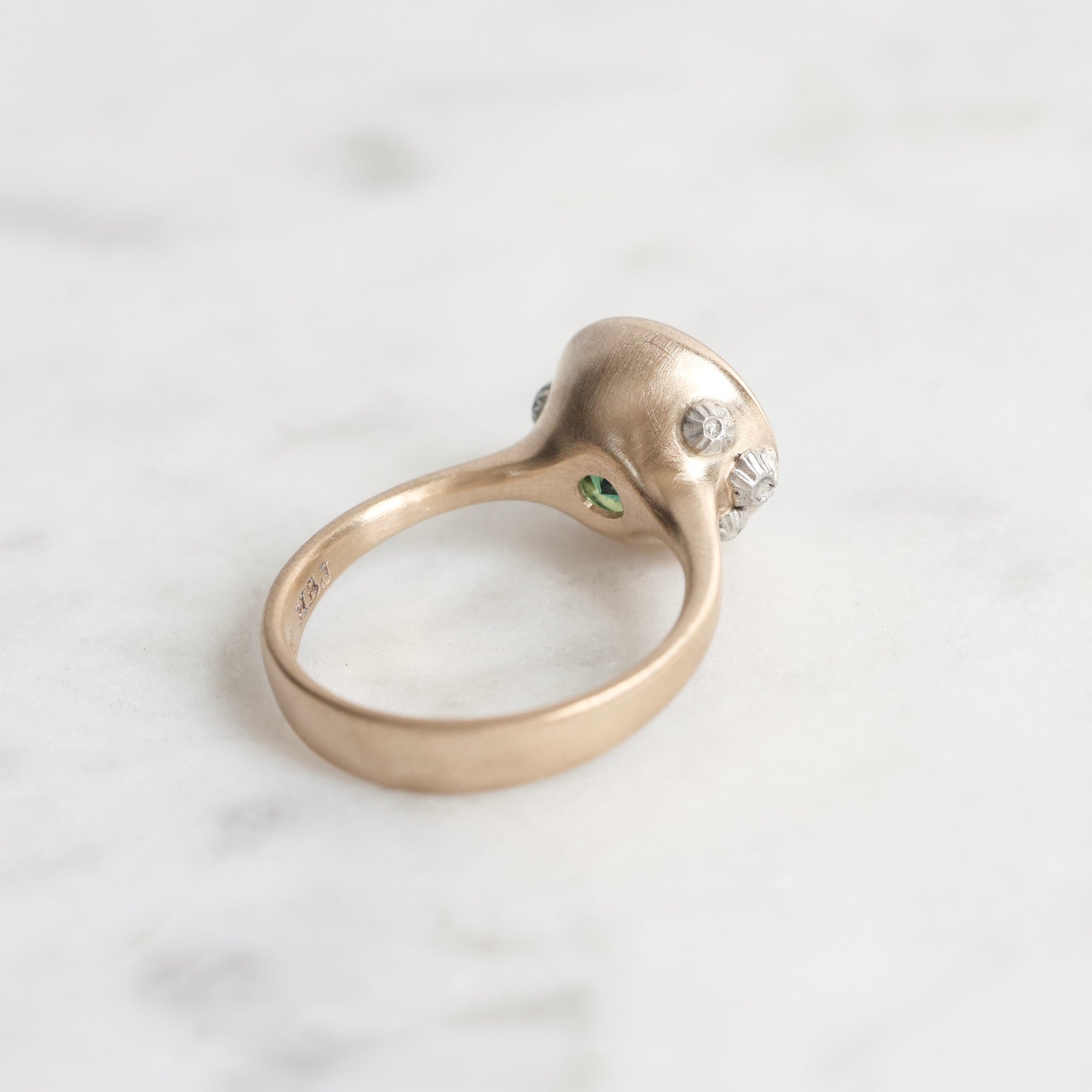 Silver ring with gemstones on a light gray background