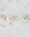 Pearl necklace with a silver clasp on a marble surface