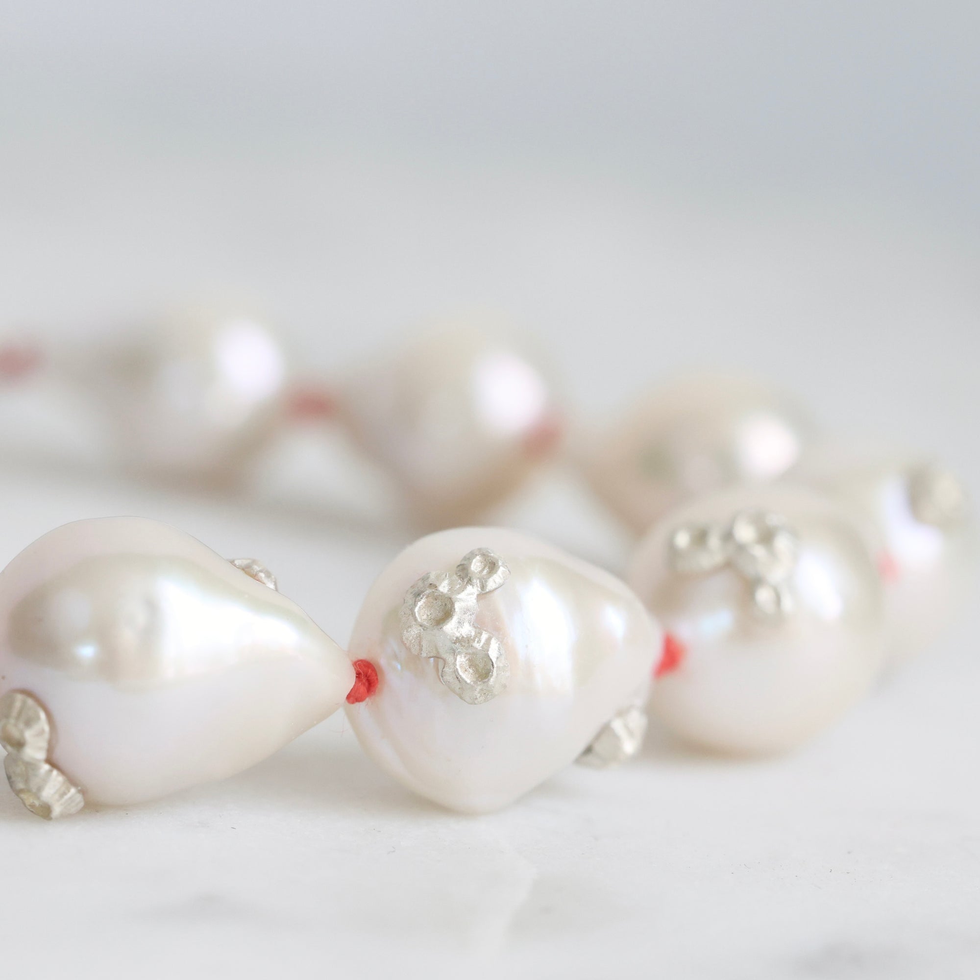 Pearl necklace with a close-up of a pearl on a light background