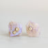 Raw opal studs with gold barnacle details against a white background. 