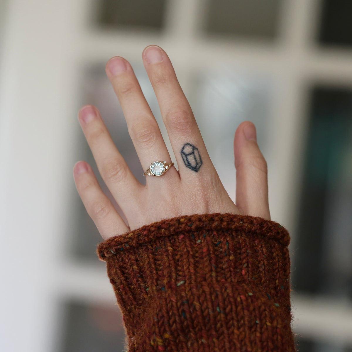 Hand wearing aquamarine ring. 