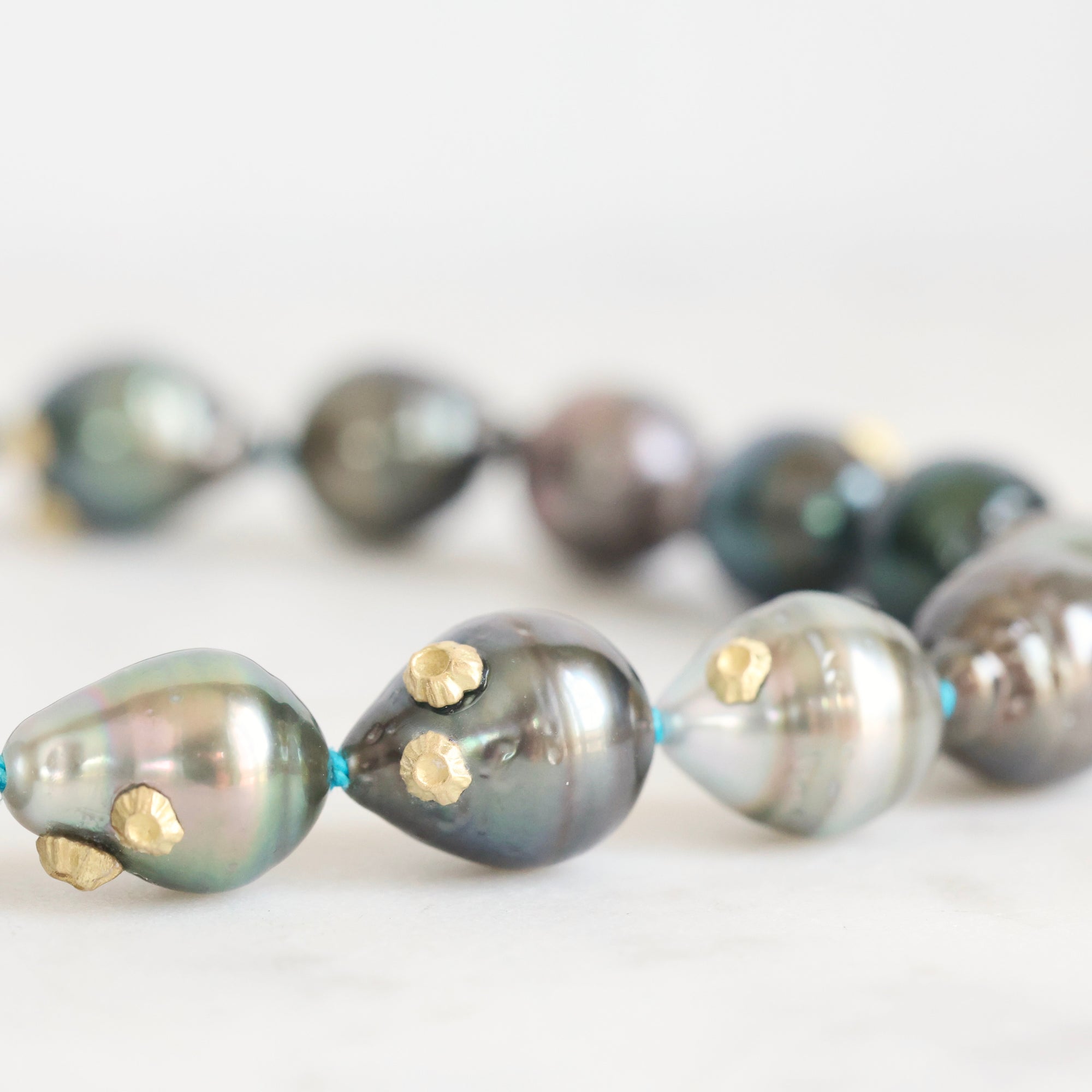 Pearl necklace with gold accents on a light background