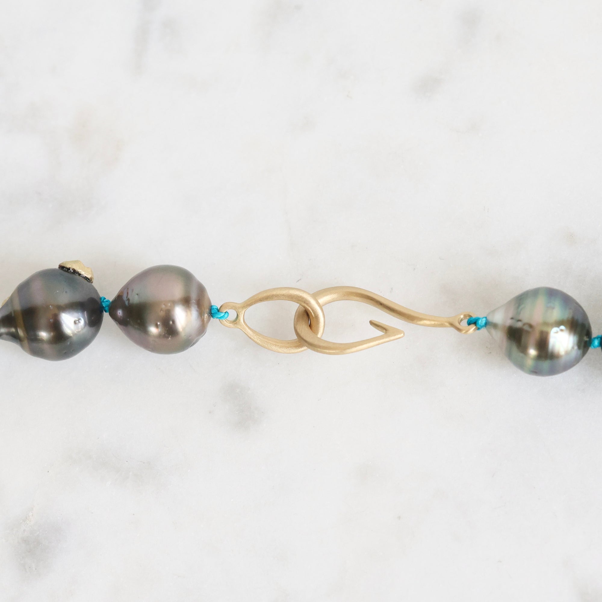 Pearl necklace with gold clasp on a white background