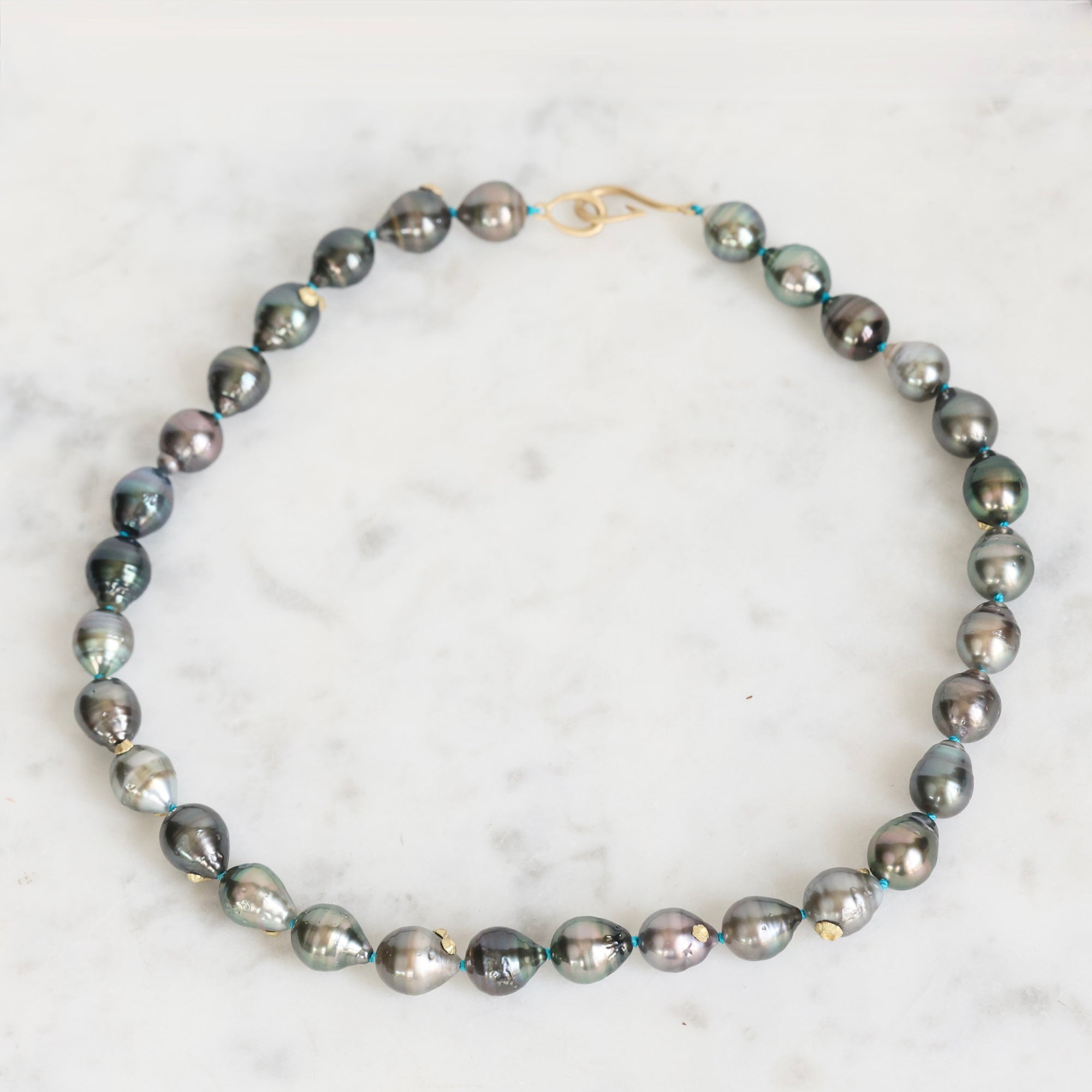 Gray pearl necklace on a marble surface