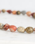 Close-up of a beaded necklace with multicolored beads on a white background