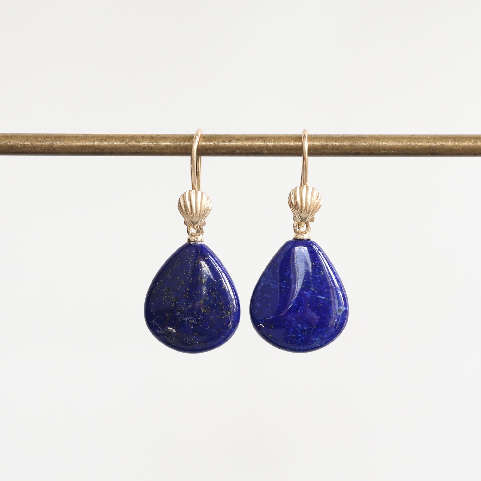 Bright blue lapis earrings with gold ear wires accented with a shell detail