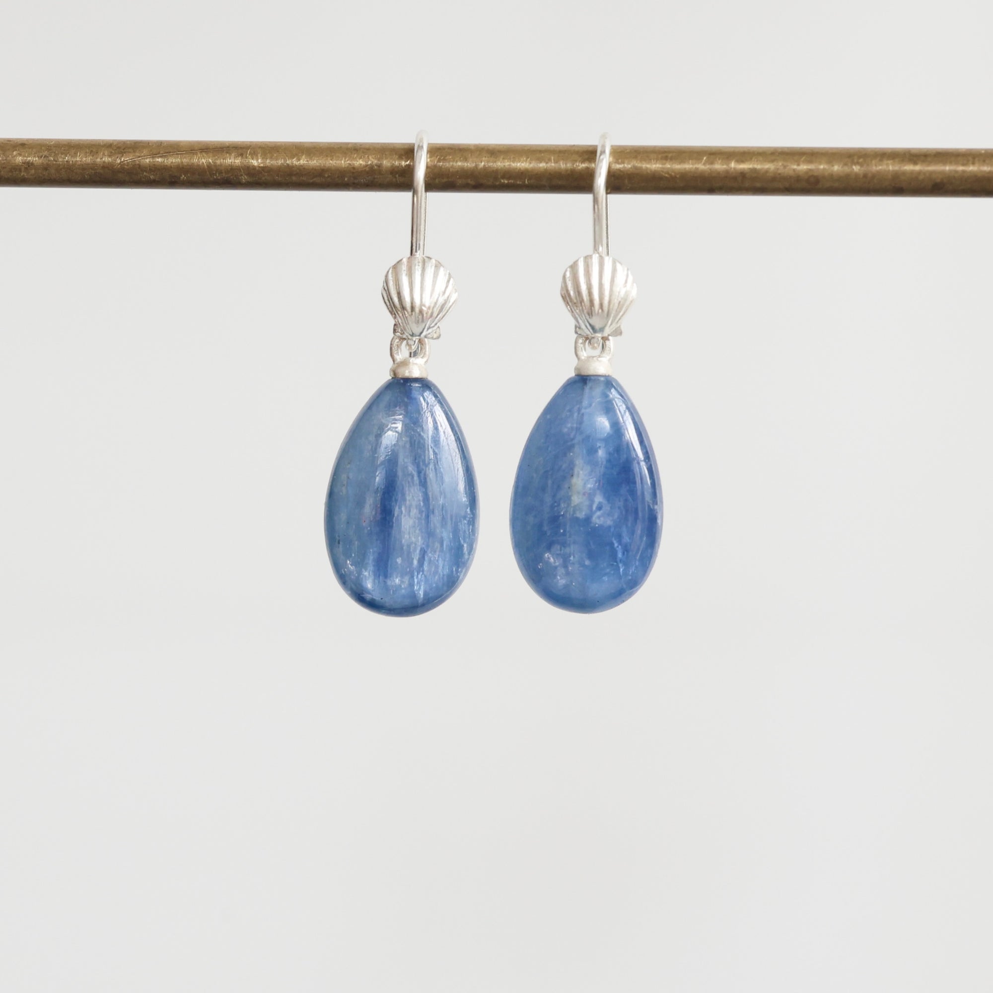 Teardrop-shaped blue gemstone earrings on a white background