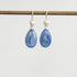 Teardrop-shaped blue gemstone earrings on a white background