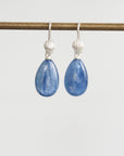 Teardrop-shaped blue gemstone earrings on a white background