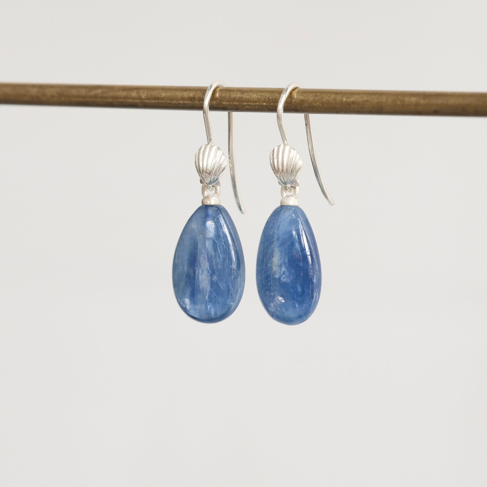 Pair of blue teardrop earrings on a white background