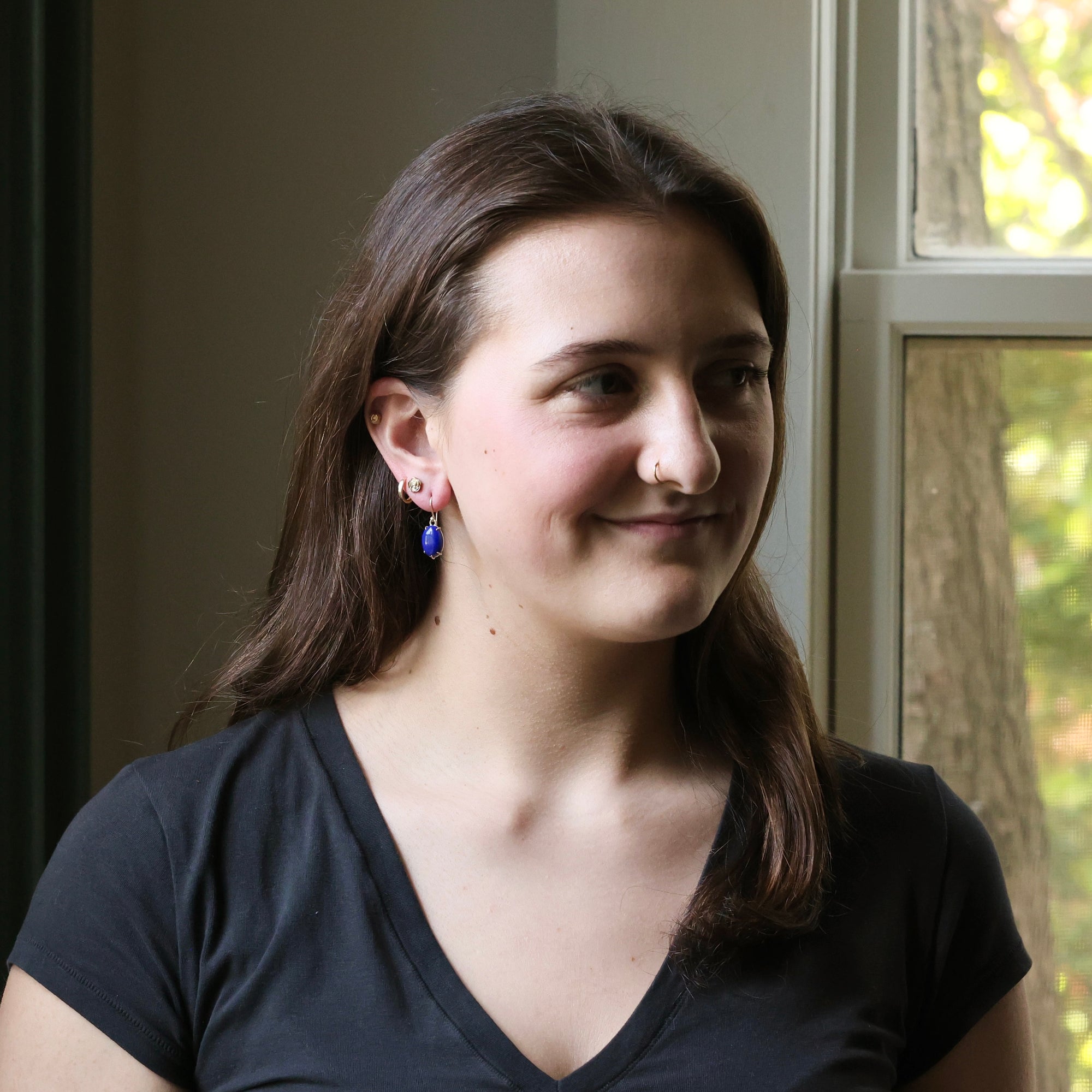 Woman wearing a black shirt with a window in the background