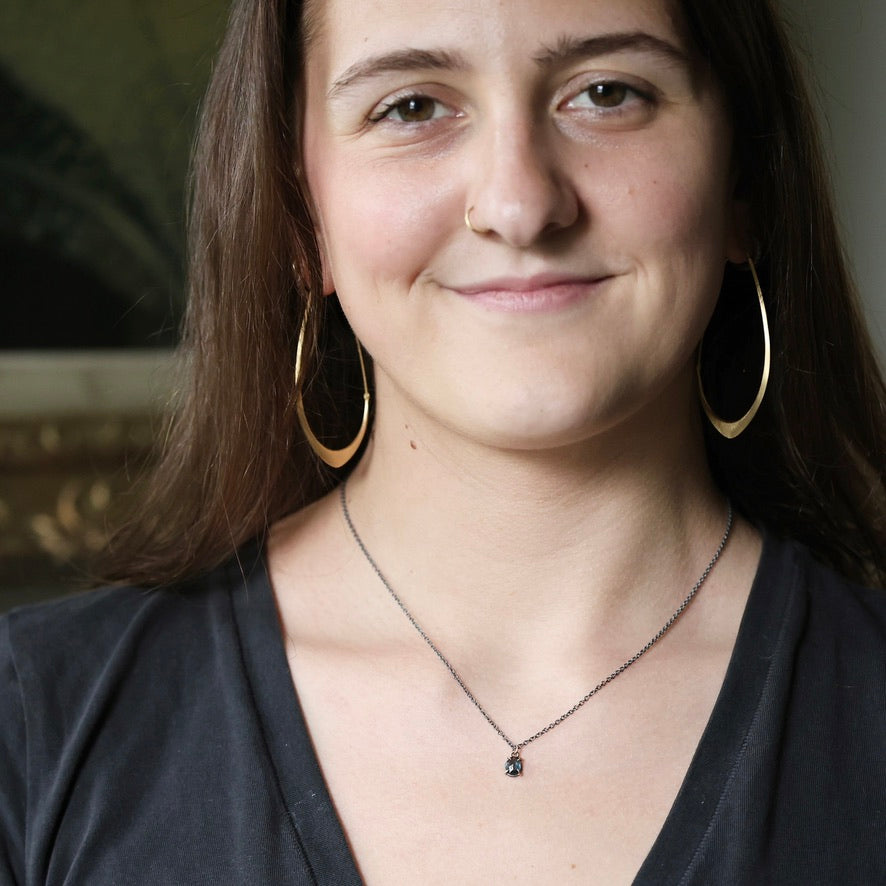 Woman wearing small blue stone necklace
