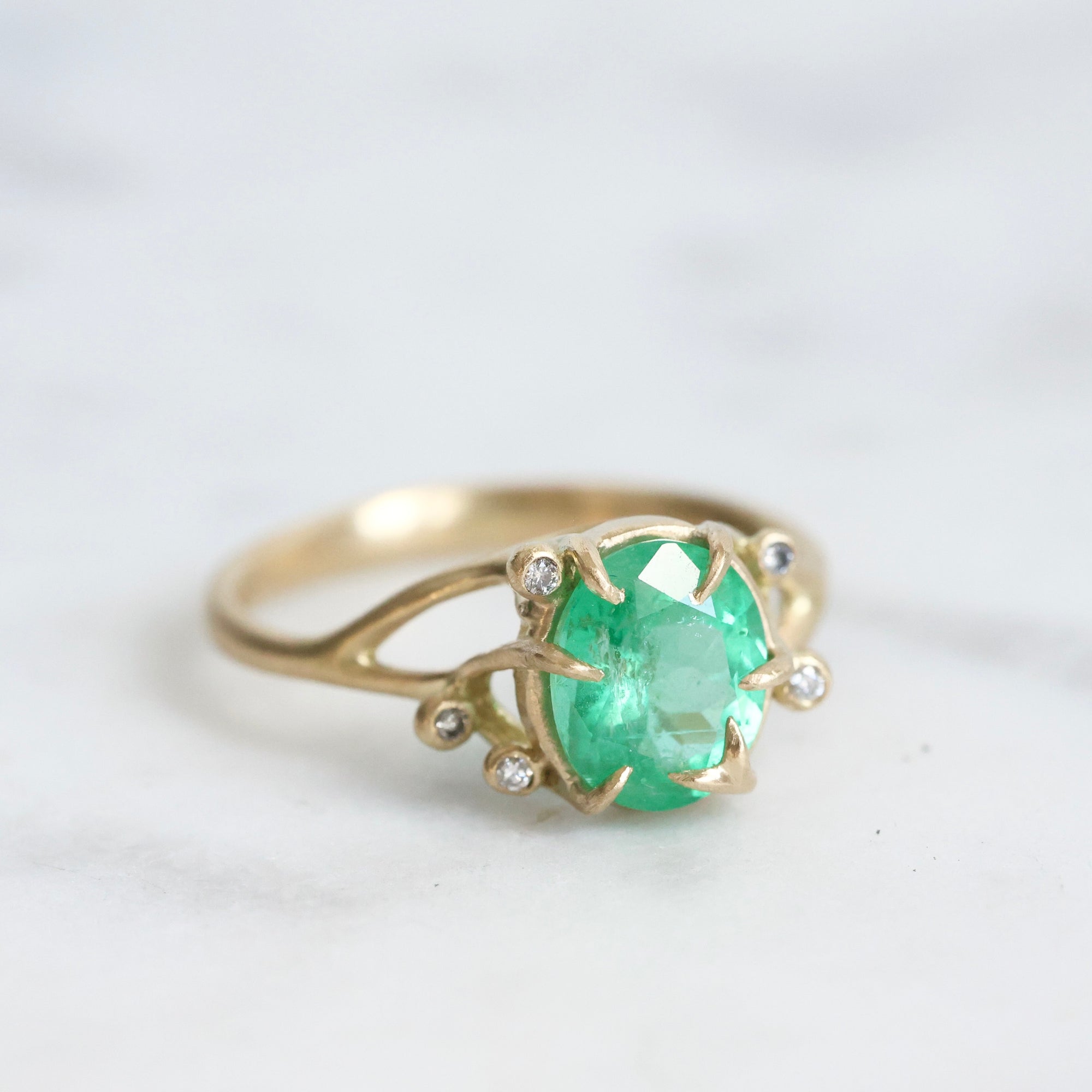 Bright green stone ring with diamonds and branchy prongs