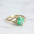 Bright green stone ring with diamonds and branchy prongs