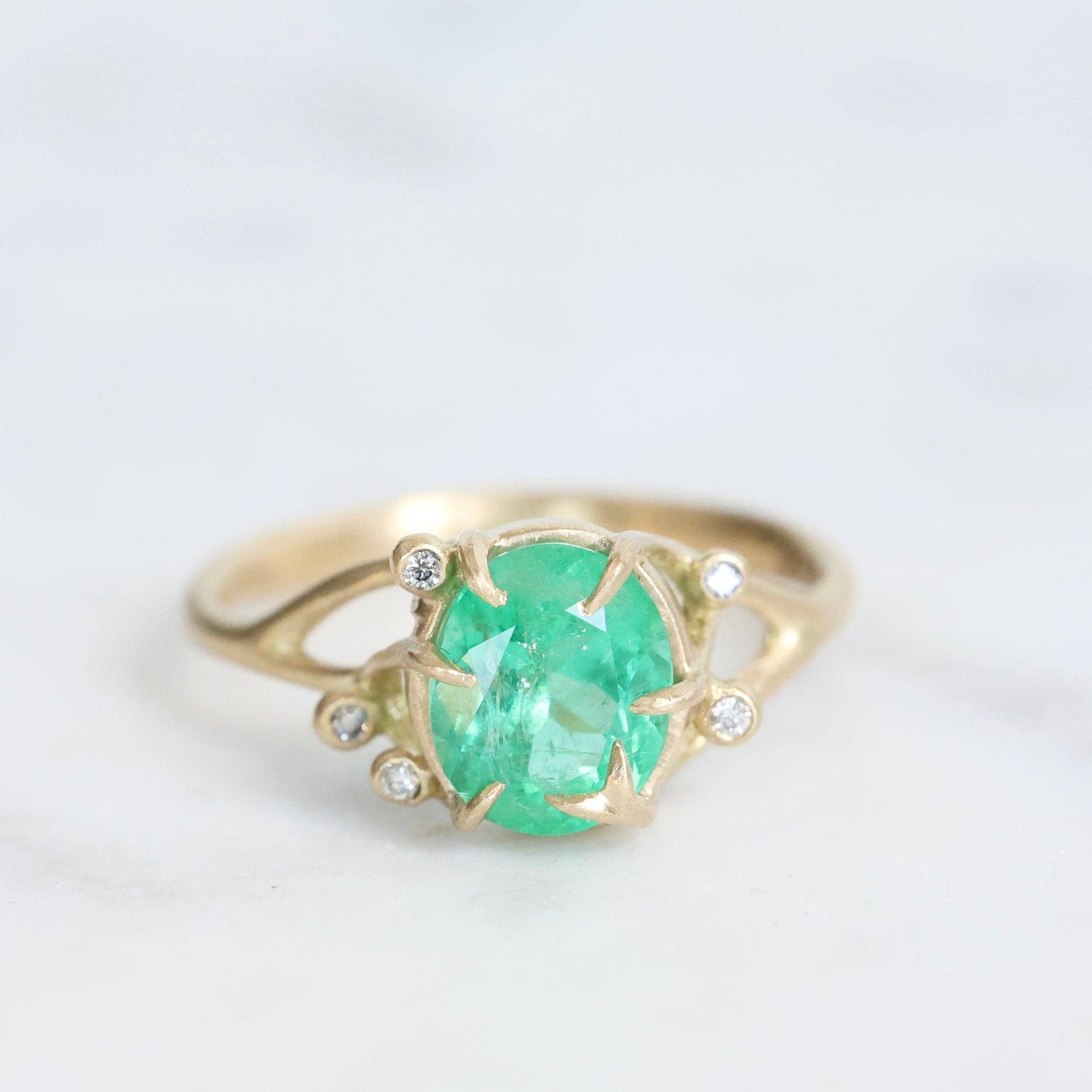 Bright green stone ring with diamonds and branchy prongs