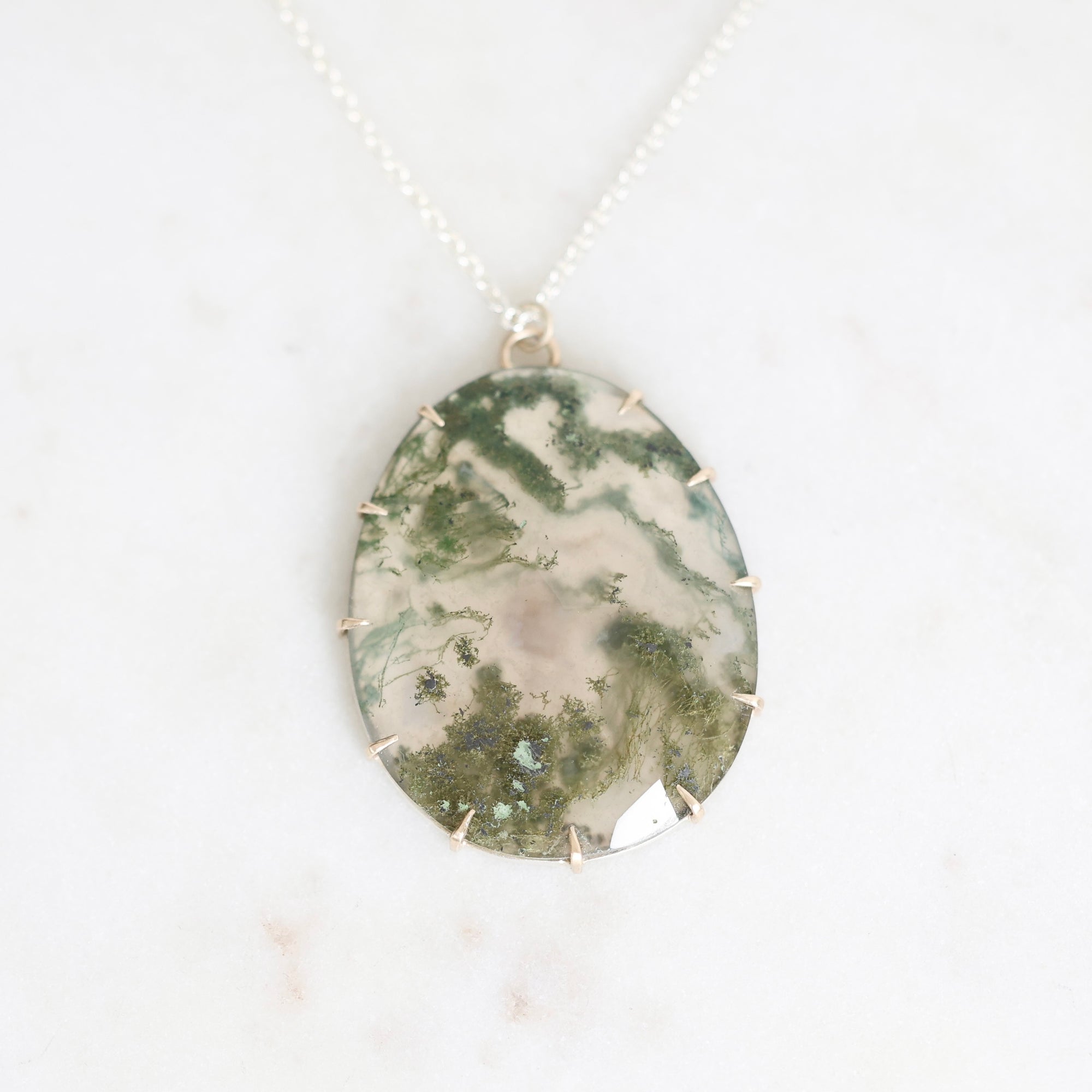 Moss agate pendant set in gold prongs 