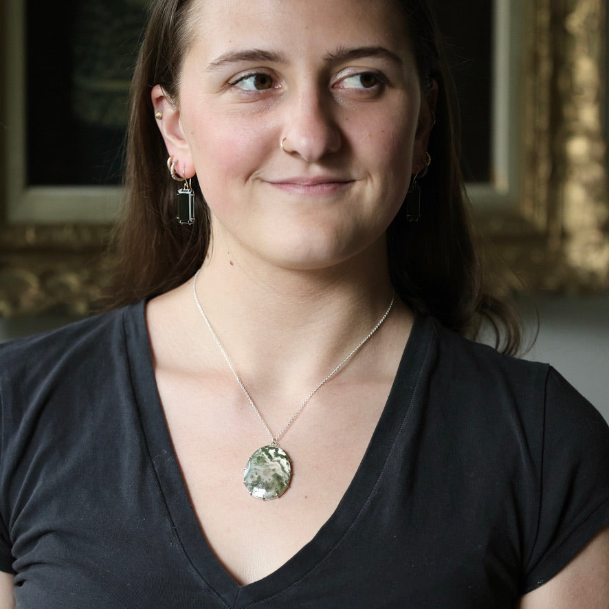 woman wearing large moss agate stone pendant 