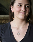 Woman wearing blue topaz necklace
