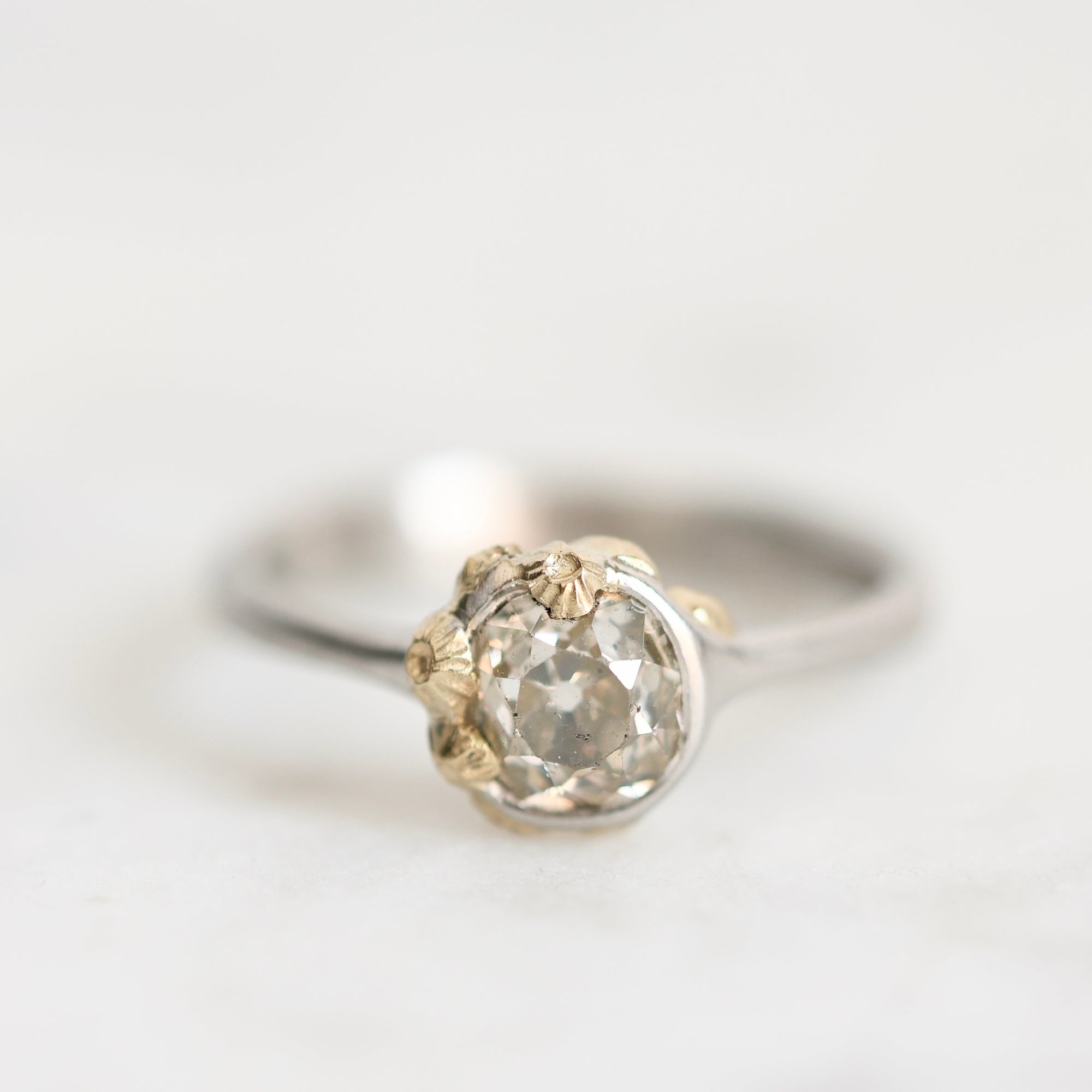 Diamond ring set in platinum bezel with gold barnacles clinging 