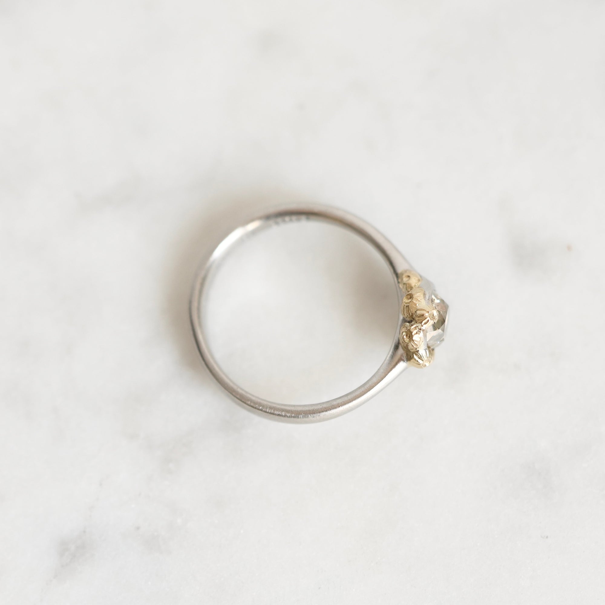 top down photo of platinum ring with gold barnacles 
