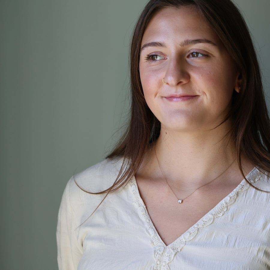 Woman wearing a white blouse with a plain background